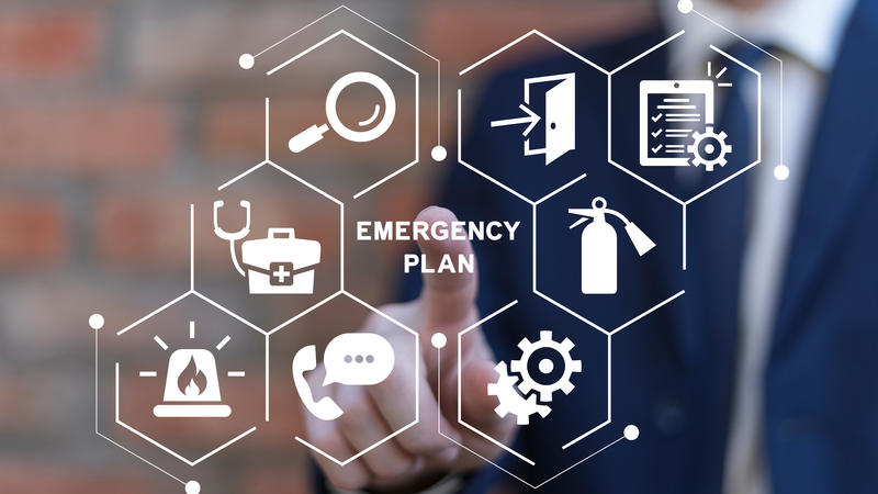 Man behind clear screen pointing to various emergency preparedness-related icons